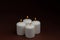 Four whiteÂ candlesÂ flameÂ burningÂ onÂ dark backgroundÂ withÂ copyÂ space forÂ text